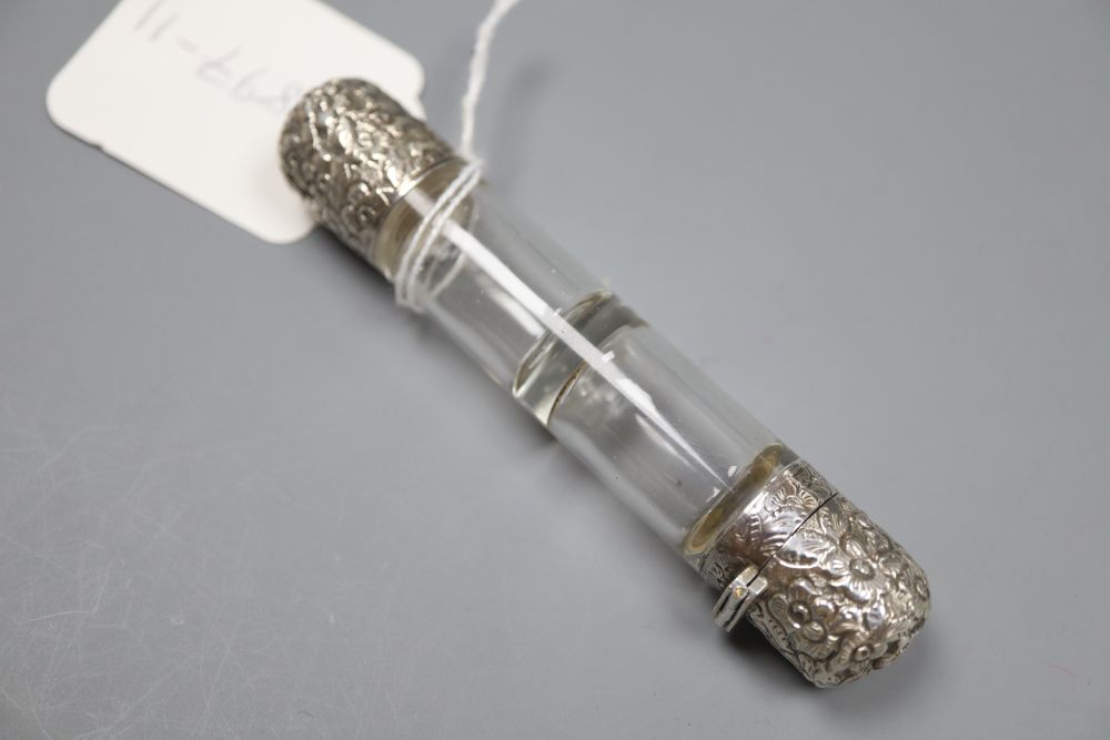 A late Victorian repousse white metal mounted double ended glass scent bottle, 10.7cm.